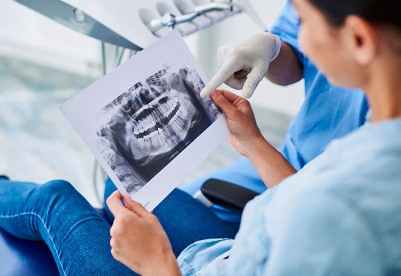 Paciente observando radiografía de dentadura